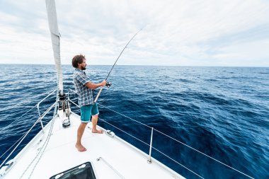 Young man fishing hard clipart