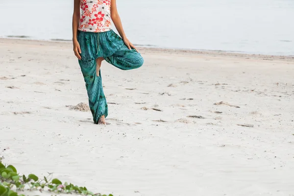 Dame dehnt sich am Strand — Stockfoto