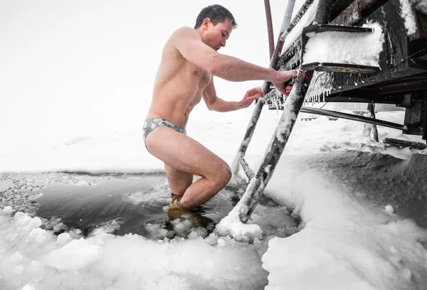 Молодой человек плавает в ледяной яме — стоковое фото