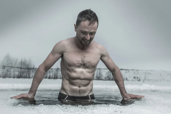 Человек купается в ледяной яме — стоковое фото