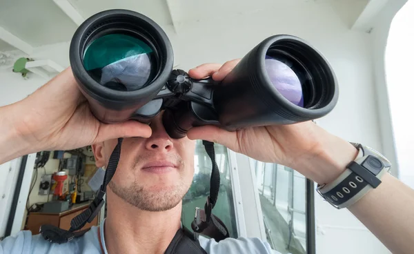 Homem olha através de binóculos do barco — Fotografia de Stock