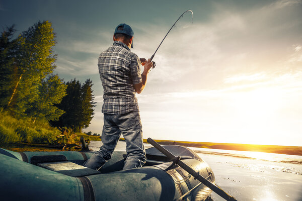 Зрелый мужчина рыбачит на озере
