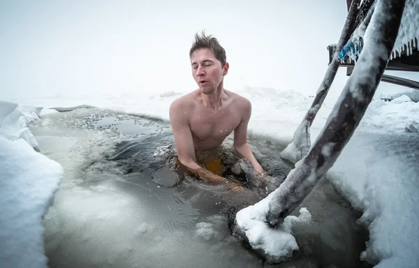 Junger Mann schwimmt im Eisloch — Stockfoto