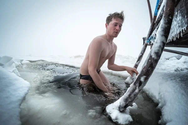 Jeune homme nageant dans le trou de glace — Photo