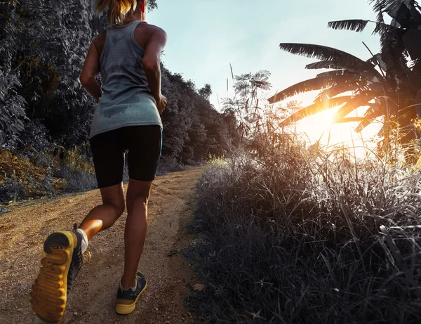 Vrouw joggen op de weg — Stockfoto