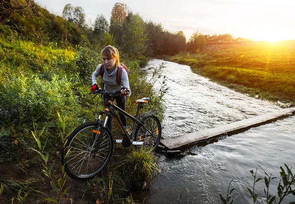 Dame überquert mit Fahrrad den Fluss — Stockfoto