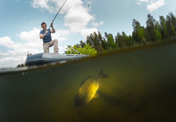 Fisherman with rod in the boat — Stock Photo, Image