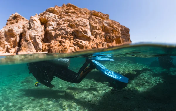 Diver underwater and rocky land — Stock Photo, Image