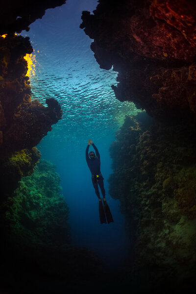 Свободное плавание ныряльщика в пещере
