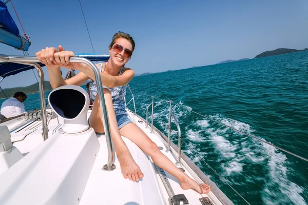 Lachende meisje in glazen zittend op een jacht — Stockfoto