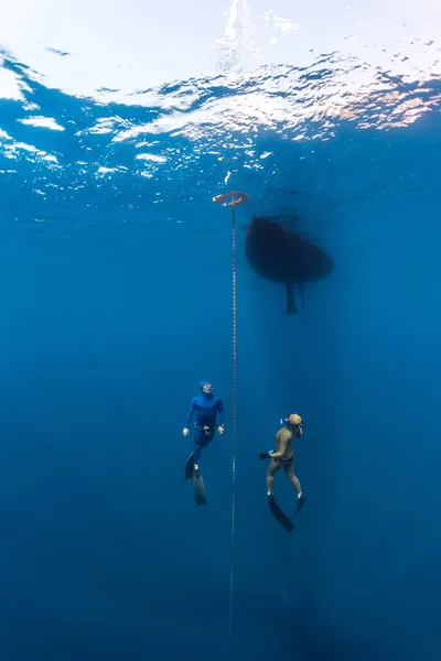 Divers swimming under the water — Stock Photo, Image