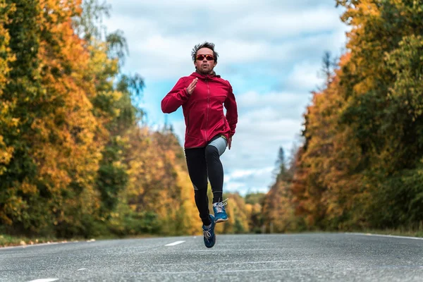 Homme courant sur la route dans la forêt — Photo