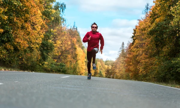 Man loopt op de weg in het bos — Stockfoto