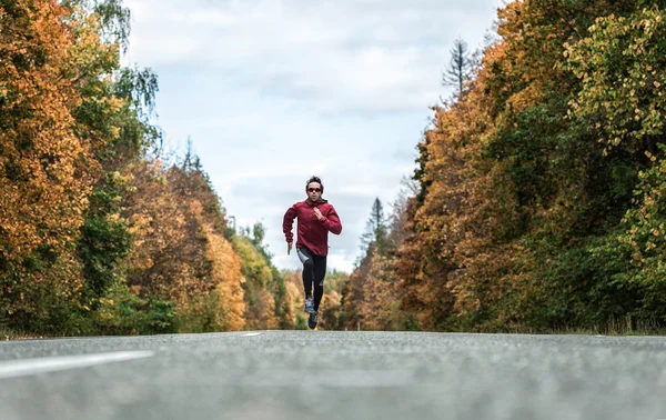 Man loopt op de weg in het bos — Stockfoto