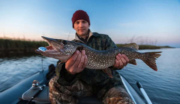 Giovane pescatore con luccio in mano — Foto Stock