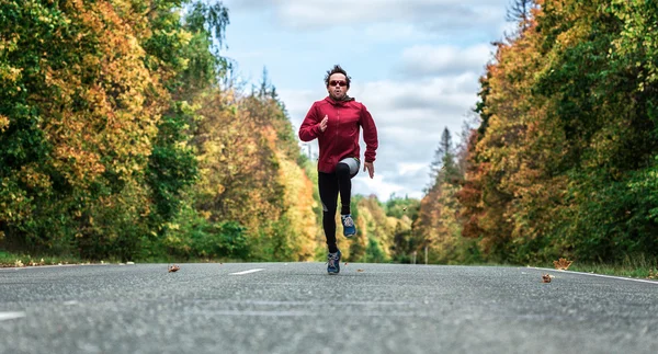 Man loopt op de weg in het bos — Stockfoto