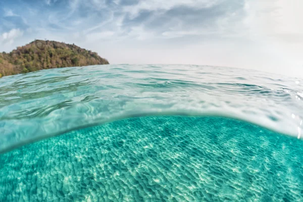 Sandy sea bottom and green tropical island — Stock Photo, Image