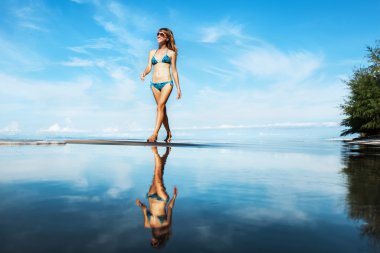 kumlu sahilde yürüyen kadın