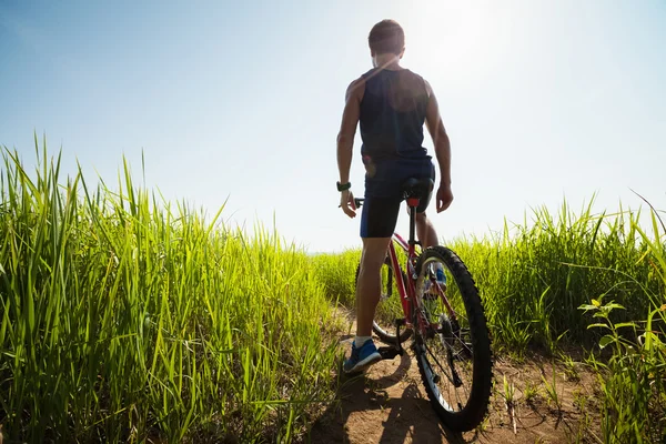 Junge Reiterin steht auf einer grünen, saftigen Wiese — Stockfoto