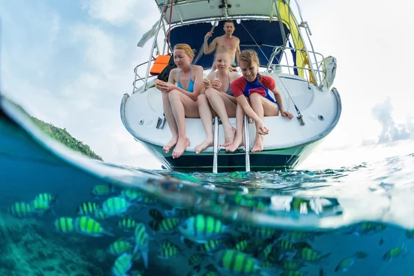 Friends feed fish from a boat — Stock Photo, Image