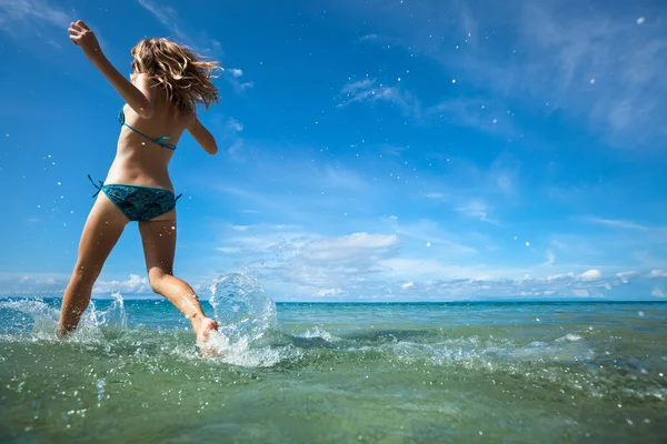 Молодая женщина бежит в море — стоковое фото