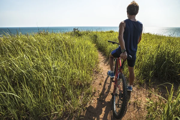 Homem de pé com uma bicicleta — Fotografia de Stock