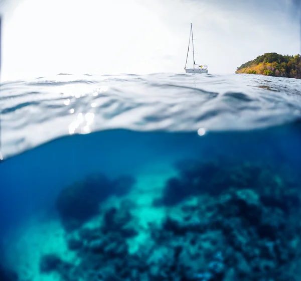 Coral reef and sailing boat — Stock Photo, Image