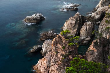 Deniz ile gündoğumu taşlara