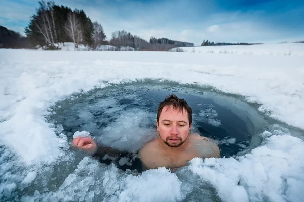 Junger Mann schwimmt im Wintersee — Stockfoto