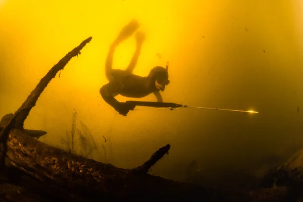 Hunter met onderwatergeweer in een meer — Stockfoto