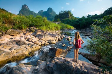 Kayanın üzerinde duran Bayan uzun yürüyüşe çıkan kimse