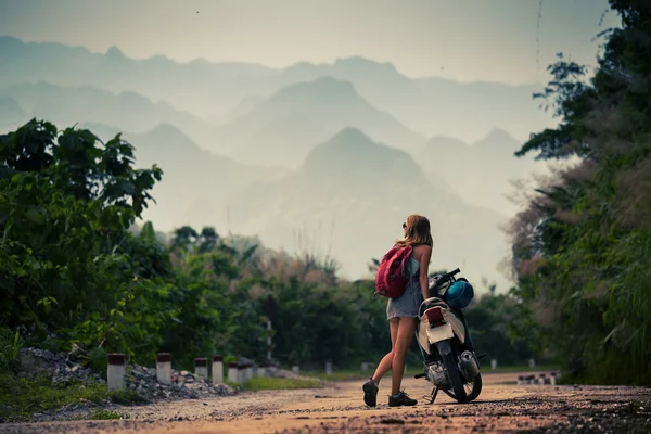 Young lady standing by her motorbike — Stock Photo, Image