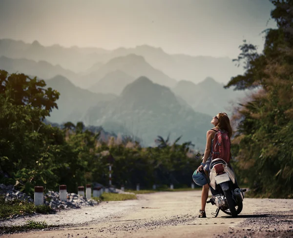 Lady biker lähellä skootteri — kuvapankkivalokuva
