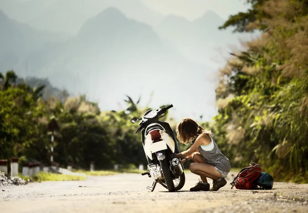 Lady biker with a motobike — Stock Photo, Image