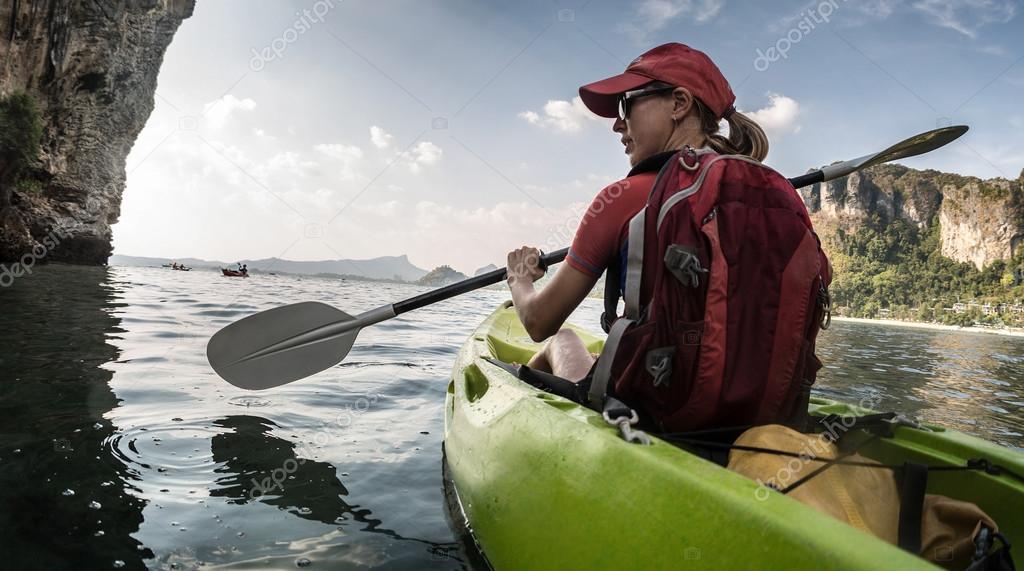 Туристы плыли по озеру на лодке. Сплав на байдарках. Человек на каяке. Девушка на байдарке. Плавать на каноэ.
