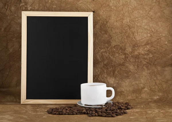 Xícara com café quente, grãos e papelão de boletins — Fotografia de Stock