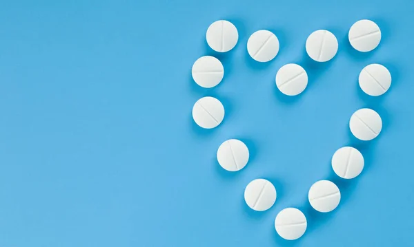 Vita Piller Som Anges Form Ett Hjärta Blå Bakgrund Närbild — Stockfoto