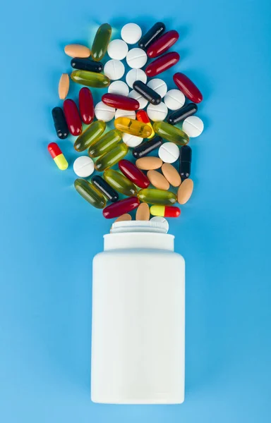 Spridning Piller Och Vit Burk Blå Bakgrund Närbild Begreppet Medicin — Stockfoto