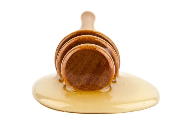 Honey dripping from a wooden dipper — Stock Photo, Image