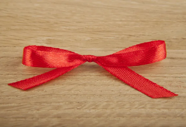Red bow on wood — Stock Photo, Image