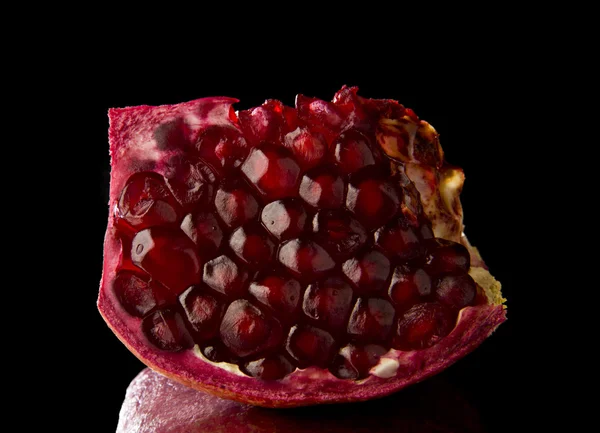 Juicy pomegranate on black — Stock Photo, Image