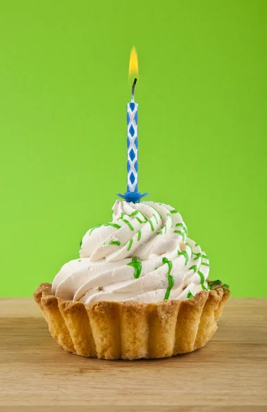 Торт со свечой на зеленом — стоковое фото