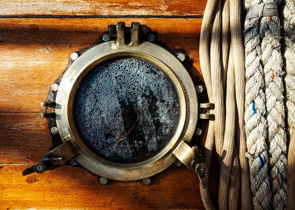 Vintage ship brass porthole and ropes — Stock Photo, Image