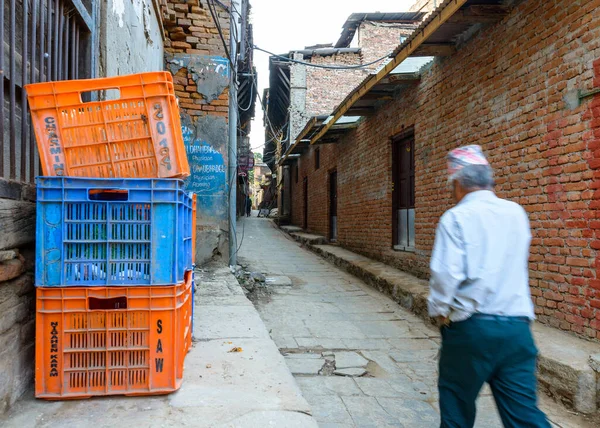 Nepalese im Topi geht eine kleine Gasse hinunter. Mit Bewegungsunschärfe. — Stockfoto