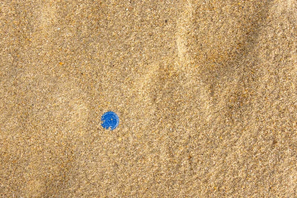 Blauwe waterfles dop in strand zand Stockfoto