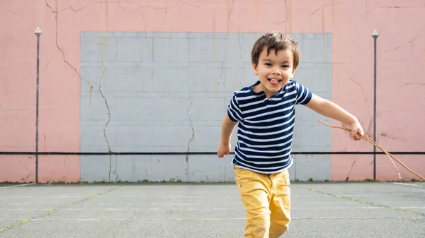 Маленький хлопчик біжить до камери на баскському пелоті Стокова Картинка