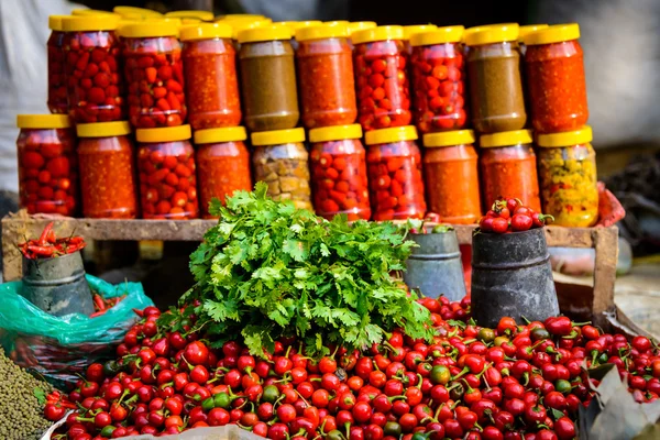 Cilantro, chile y frascos en un mercado — Foto de Stock