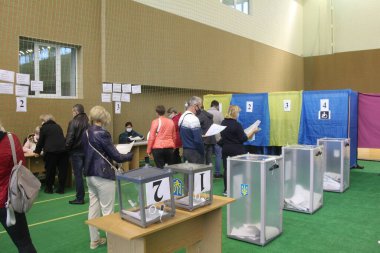 ODESSA, UKRAINE -25.10.2020 - Ukrayna 'da seçimler. COVID-19 Coronavirus salgını sırasında yerel meclis üyelerinin seçim platformu. Oy pusulalarıyla maske ve eldiven takan insanlar