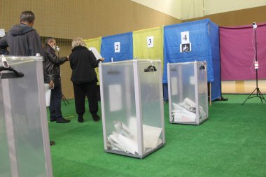 ODESSA, UKRAINE -25.10.2020 - Ukrayna 'da seçimler. COVID-19 Coronavirus salgını sırasında yerel meclis üyelerinin seçim platformu. Oy pusulalarıyla maske ve eldiven takan insanlar