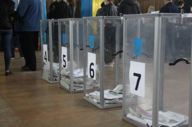 ODESSA, UKRAINE -25.10.2020 - Ukrayna 'da seçimler. COVID-19 Coronavirus salgını sırasında yerel meclis üyelerinin seçim platformu. Oy pusulalarıyla maske ve eldiven takan insanlar